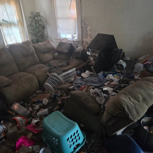 Living room packed with belongings before a home cleanout in eastern North Carolina