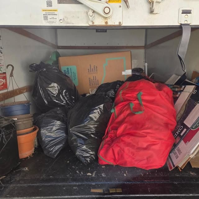 Truck loaded with bagged household junk and boxes on a junk removal job in Greenville, NC